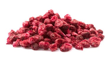 Photo of a pile of dried pomegranite seeds isolated on a white background.